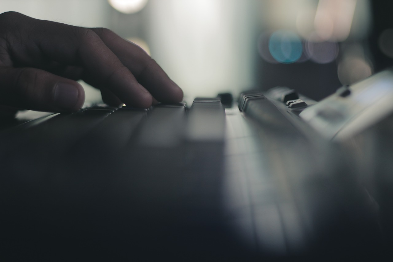 Foto da mão de uma pessoa em cima de um teclado de computador.