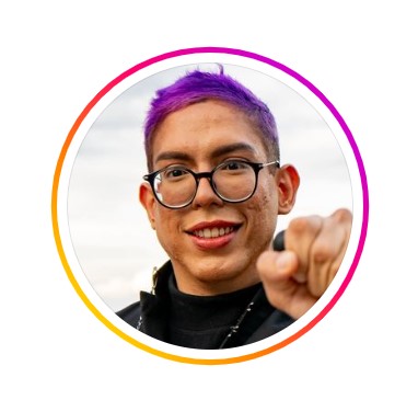 Foto de perfil de Ivan Baron. Tem pele branca, cabelos curtos tingidos de roxo, usa óculos com armação redonda na cor preta.